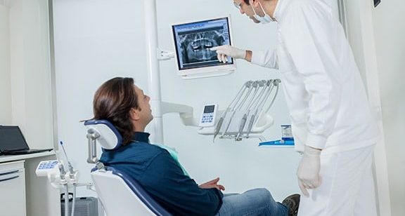 Profissional radiologista mostra para sua paciente uma radiografia digital.