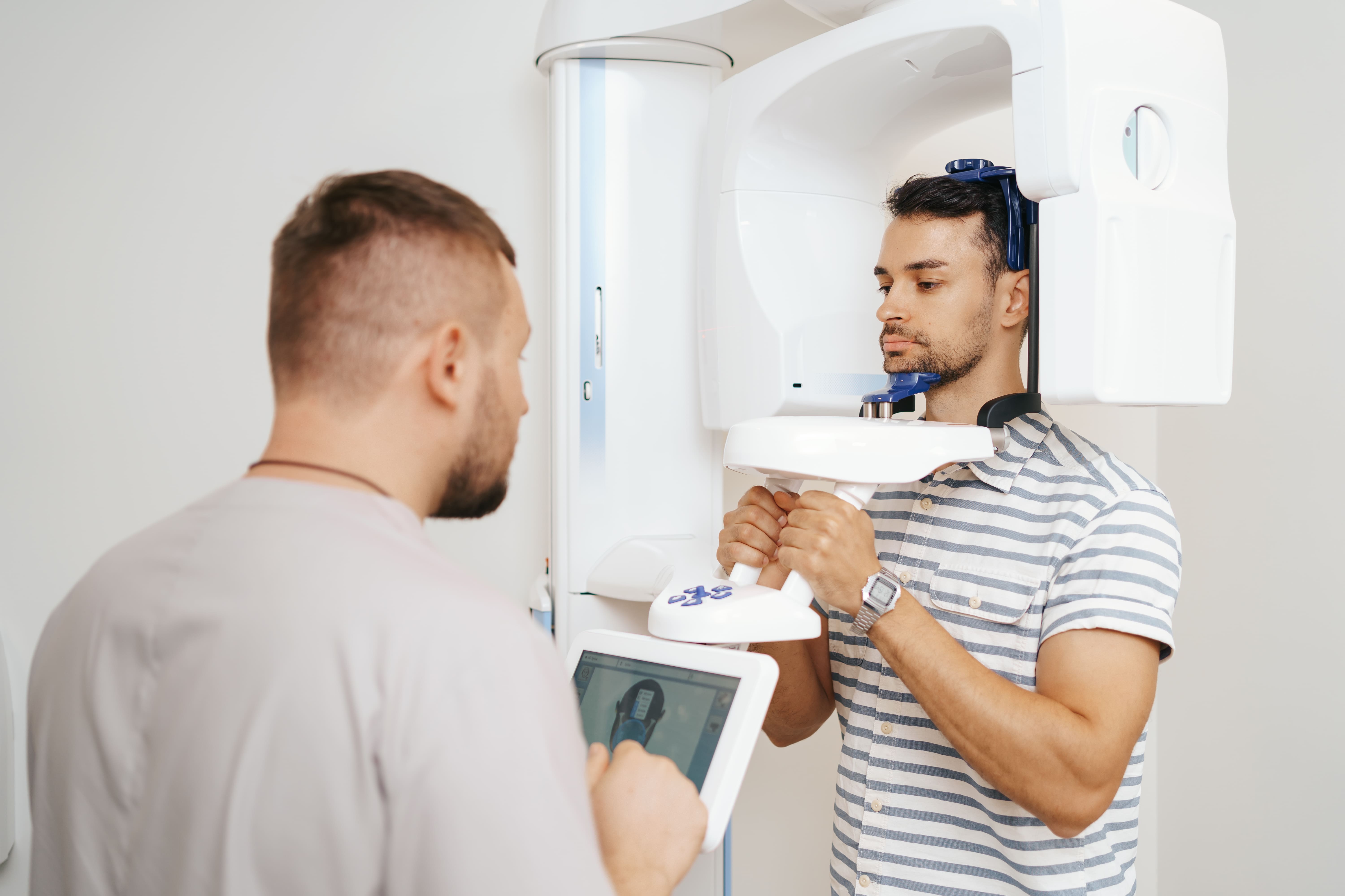 Radiologista realiza uma tomografia no paciente utilizando o tomógrafo cone beam.